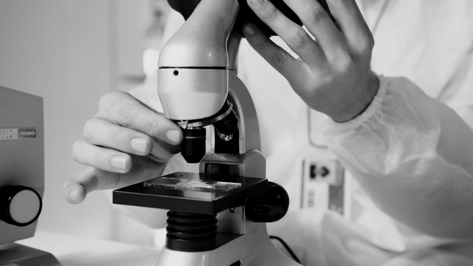 Wetenschapper met microscoop, wat zegt de wetenschap over cannabis
